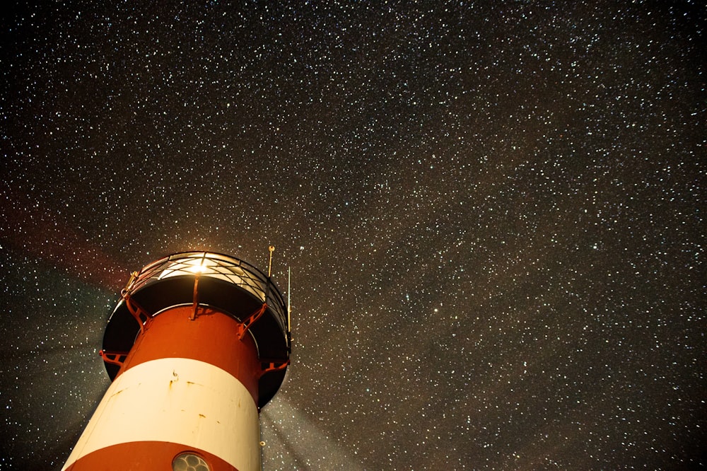 Phare orange et blanc sur sol en béton gris