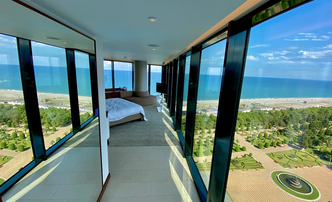 white bed near glass window,