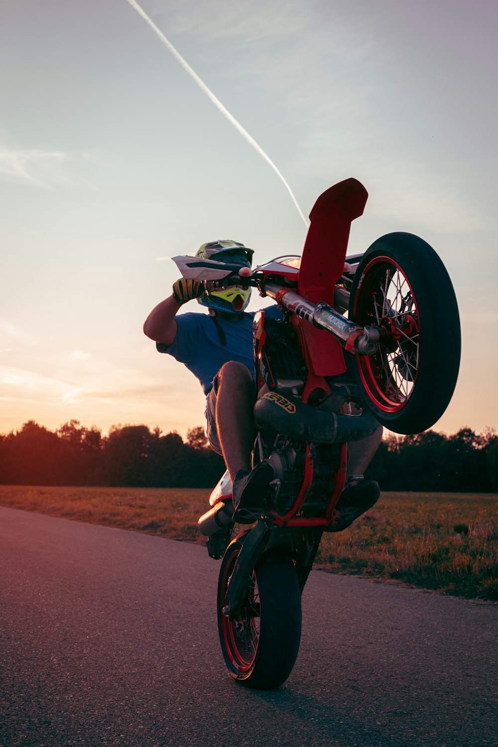 man in green shirt riding red motorcycle on road during daytime