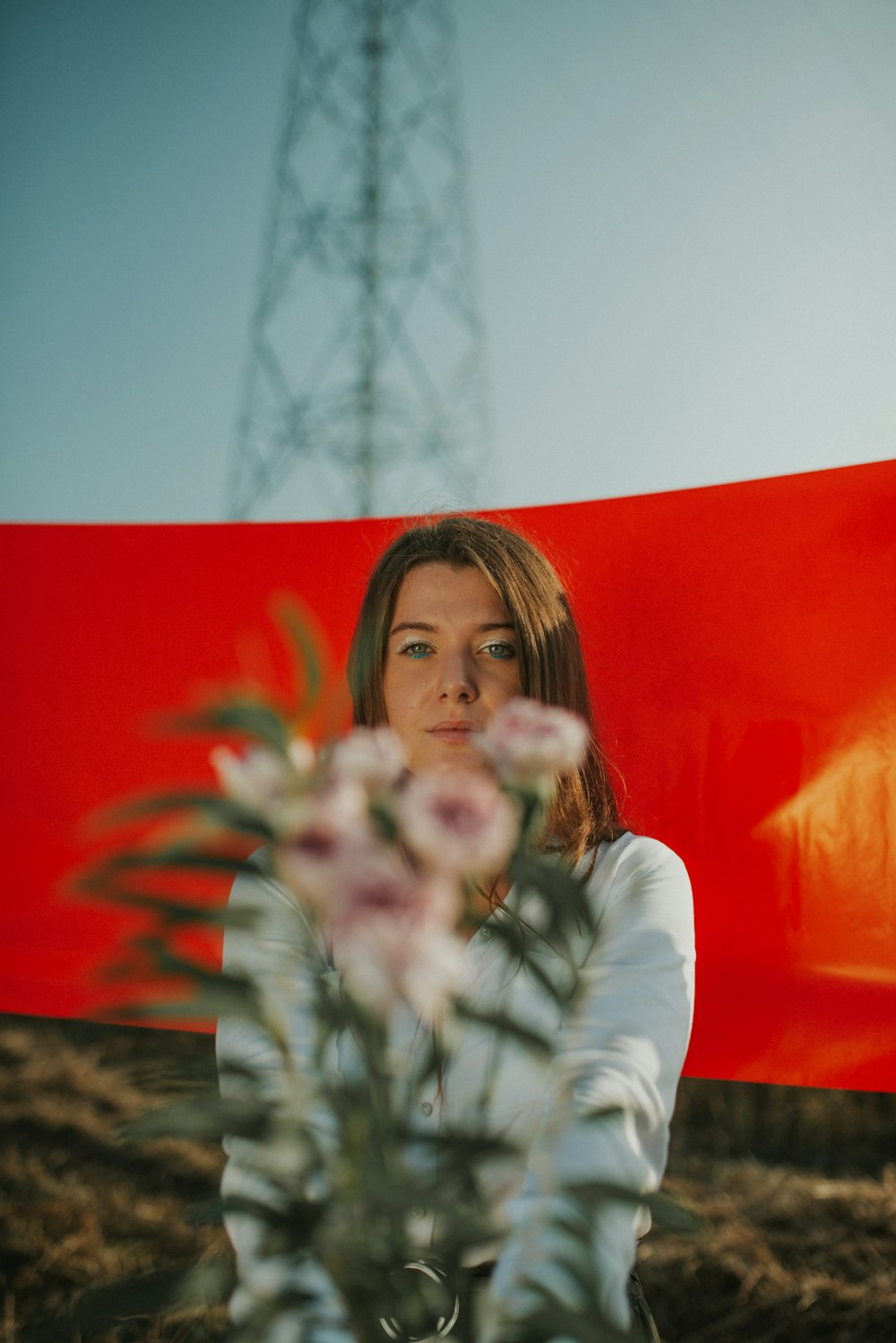 woman in white long sleeve shirt holding purple flowers