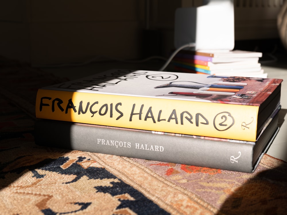 a stack of books sitting on top of a rug