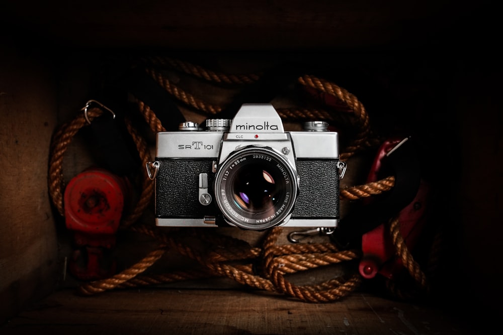 black and silver dslr camera on brown rope