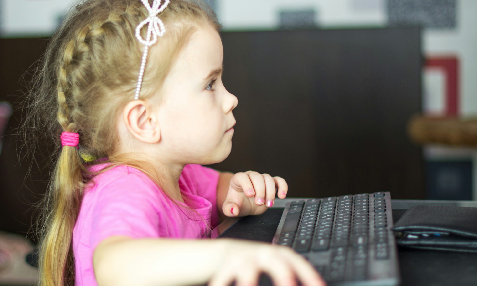 Emporium of Digital Delights. girl in pink shirt using black laptop computer