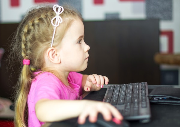 Emporium of Digital Delights. girl in pink shirt using black laptop computer
