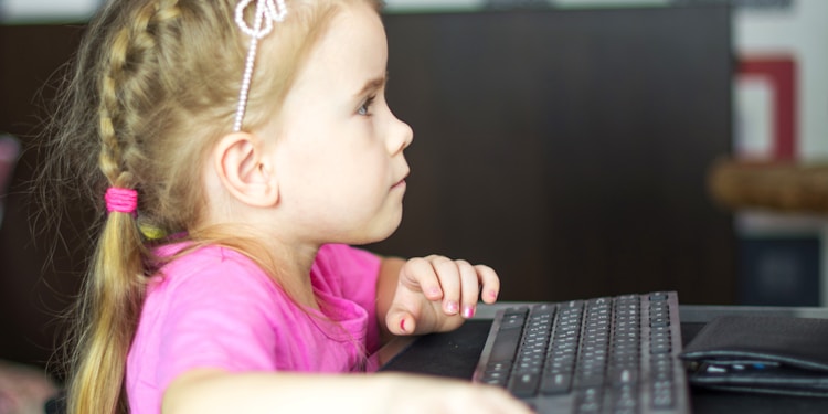 girl in pink shirt using black laptop computer