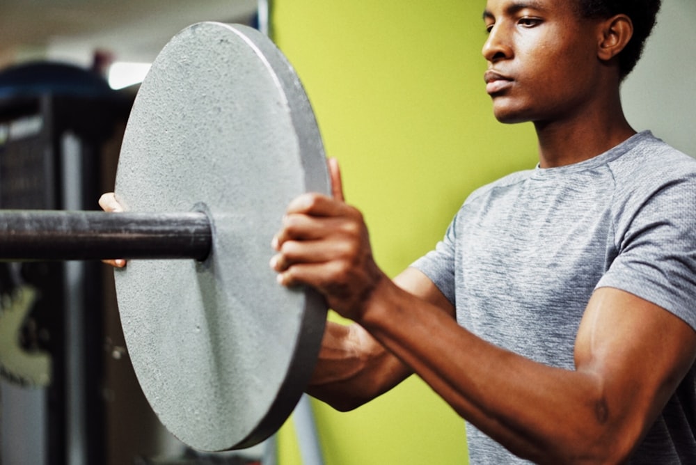 man in gray crew neck t-shirt holding gray round mirror