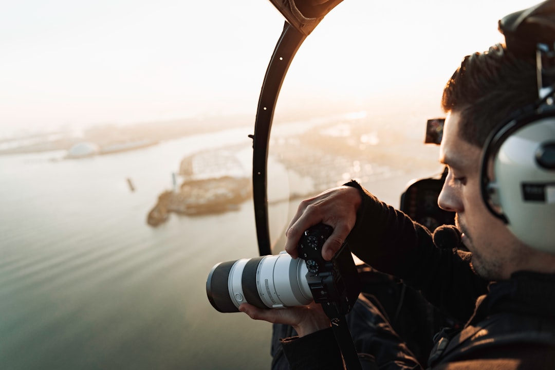 man in black jacket holding black dslr camera