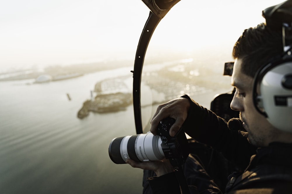 man in black jacket holding black dslr camera