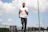 man in white crew neck t-shirt and black pants standing on field during daytime