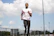 man in white crew neck t-shirt and black pants standing on field during daytime