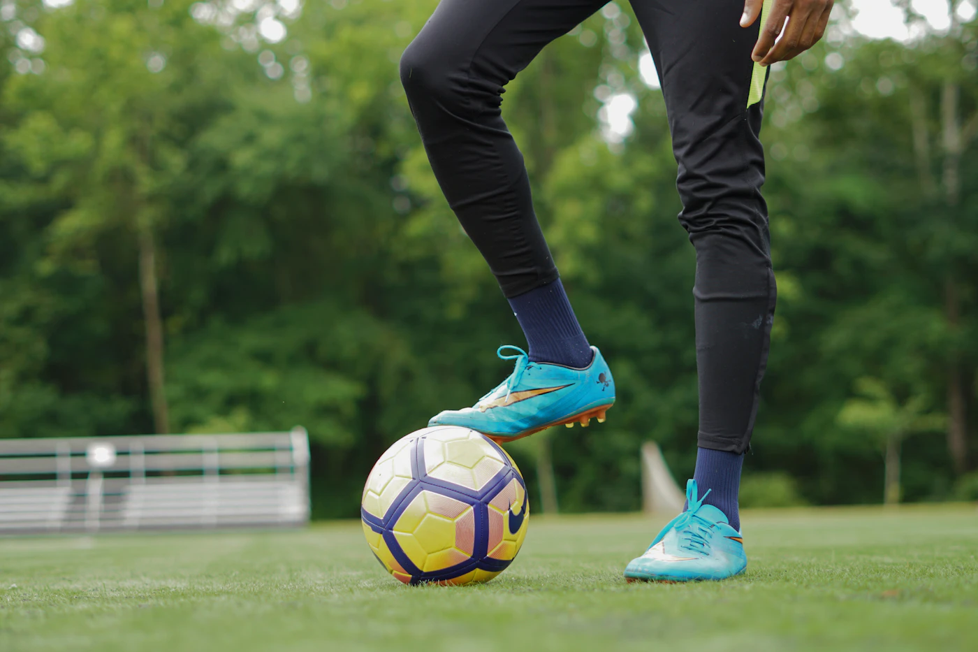 Player stepping over a ball on grass, low angle