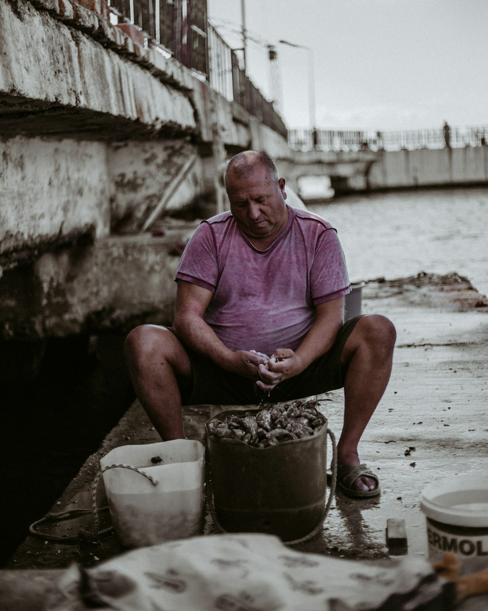 man in pink crew neck t-shirt sitting on sand