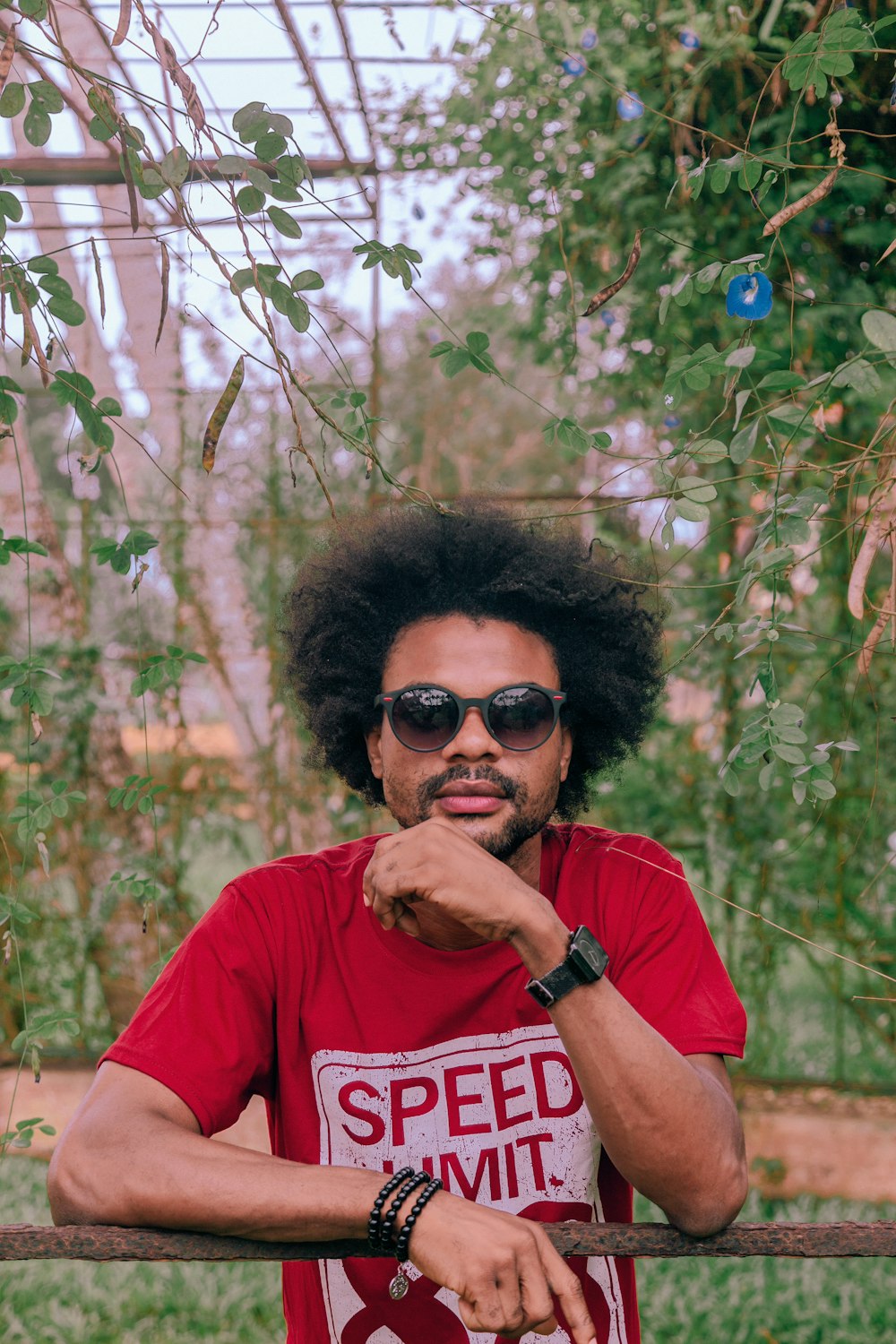 Hombre con camiseta roja de cuello redondo con gafas de sol negras