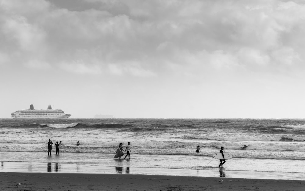 grayscale photo of people walking on beach