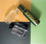 An artistic flat lay of perfume bottles surrounded by fresh flowers and green leaves.