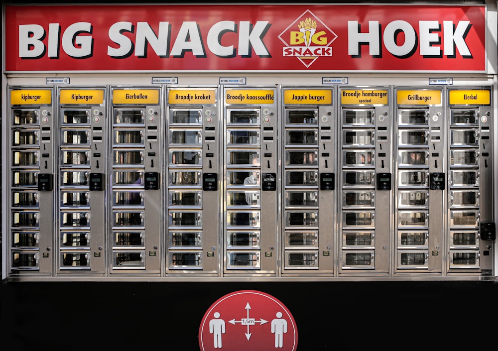 a big snack hoek machine with a red sign above it
