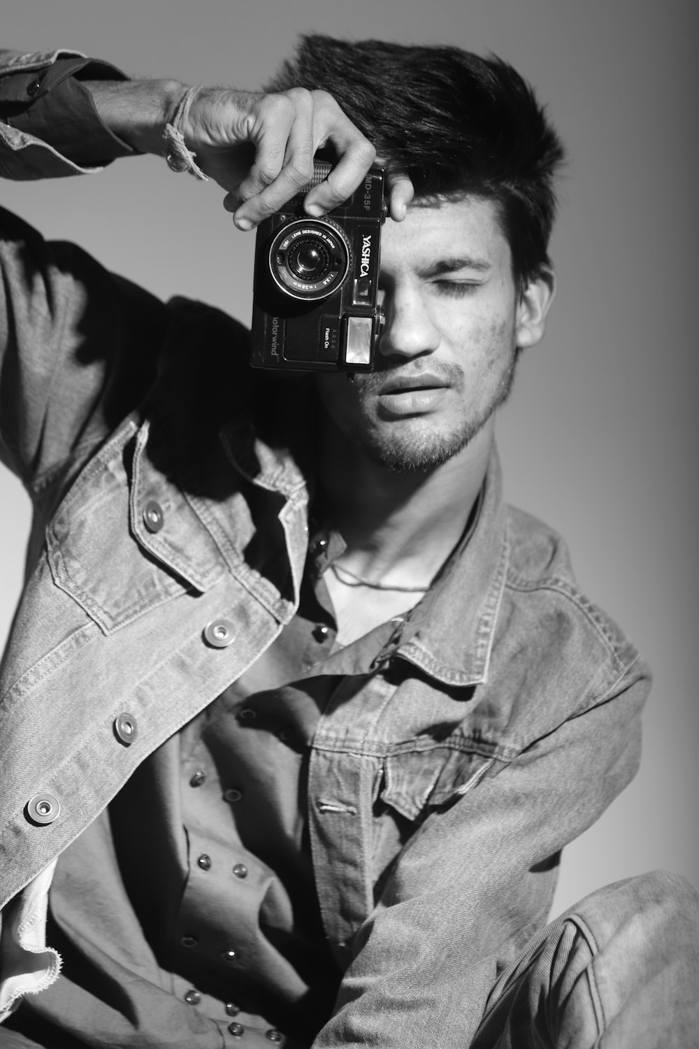 man in button up shirt holding black and silver camera