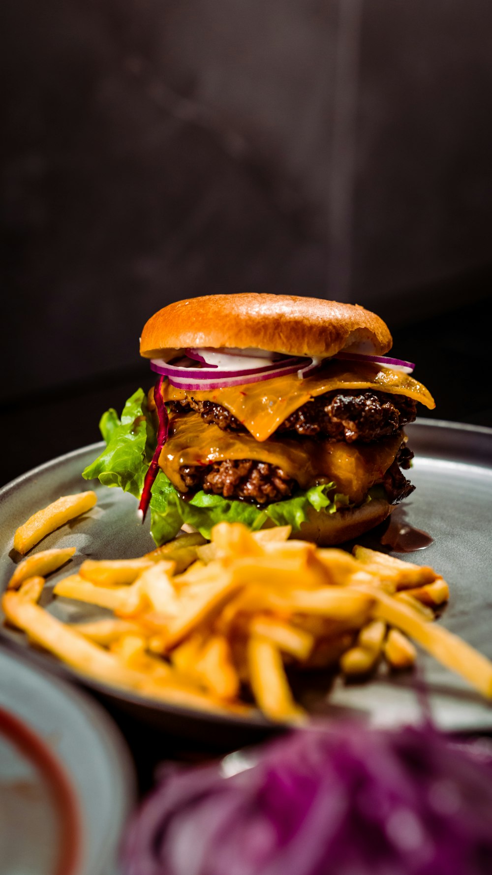 Burger und Pommes auf weißem Keramikteller