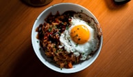 Golden fried rice with vegetables and egg, served in a rustic bowl.