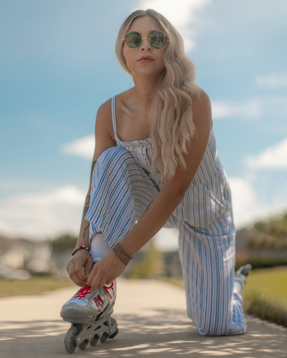 woman in white and blue striped spaghetti strap dress wearing sunglasses