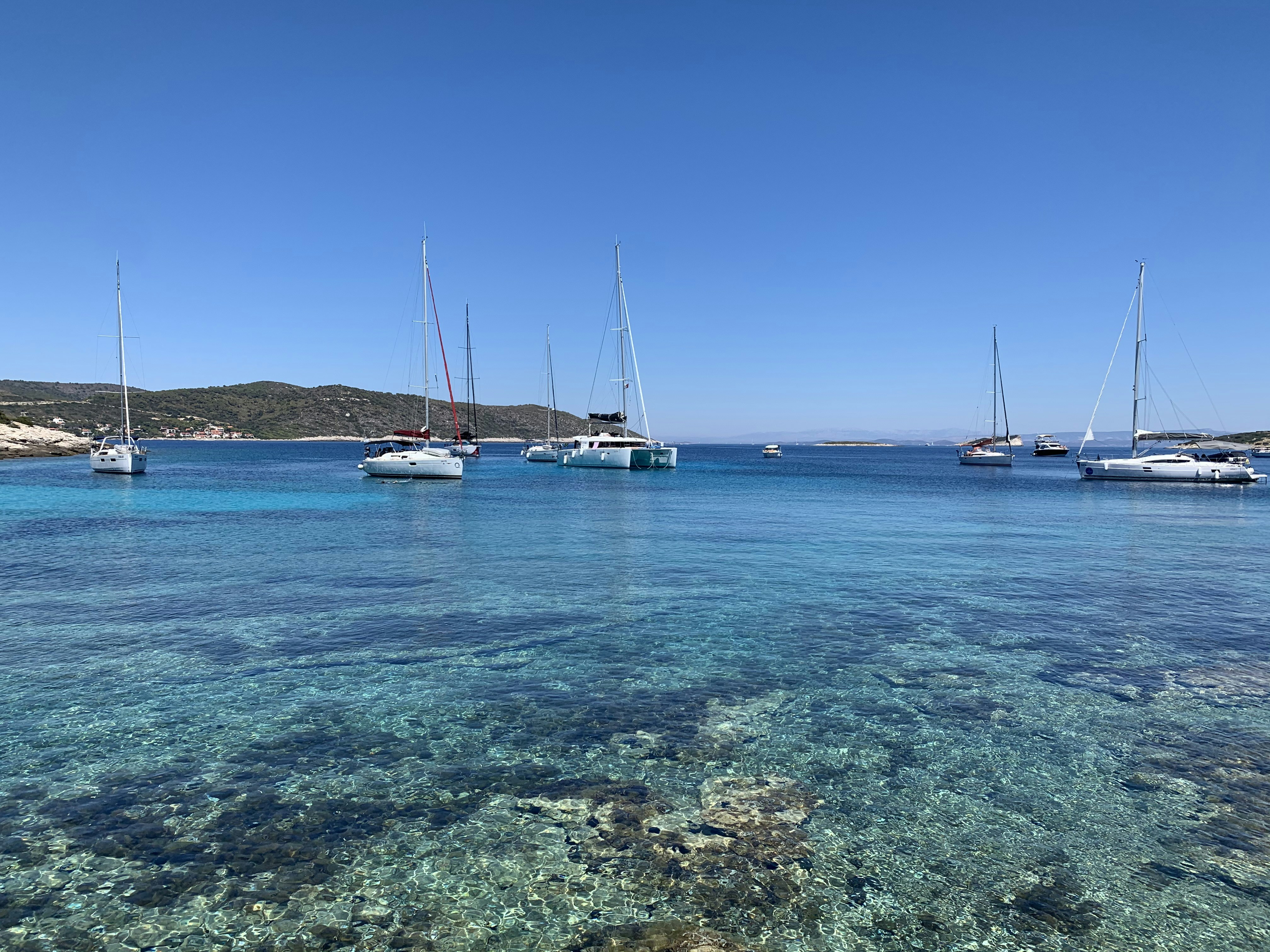 white sail boat on blue sea under blue sky during daytime