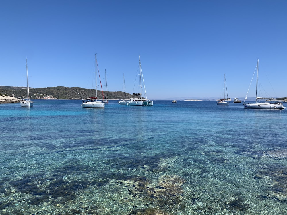 white sail boat on blue sea under blue sky during daytime