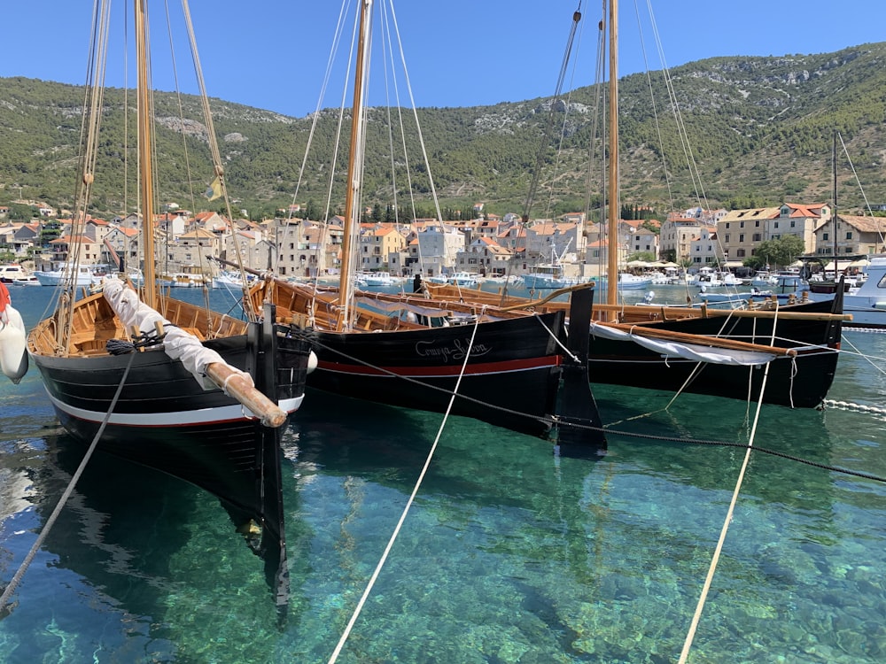 brown and white sail boat on blue water during daytime