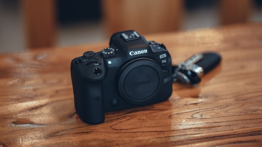 A sleek mirrorless camera resting on a wooden table with soft natural light highlighting its details.