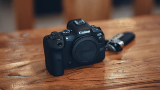 A sleek mirrorless camera resting on a wooden table with soft natural light highlighting its details.