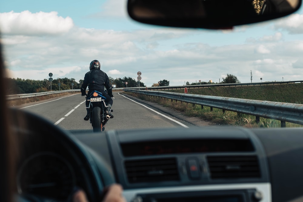 man in black jacket riding motorcycle on road during daytime