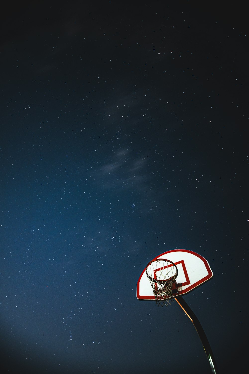 white and red basketball hoop under blue sky