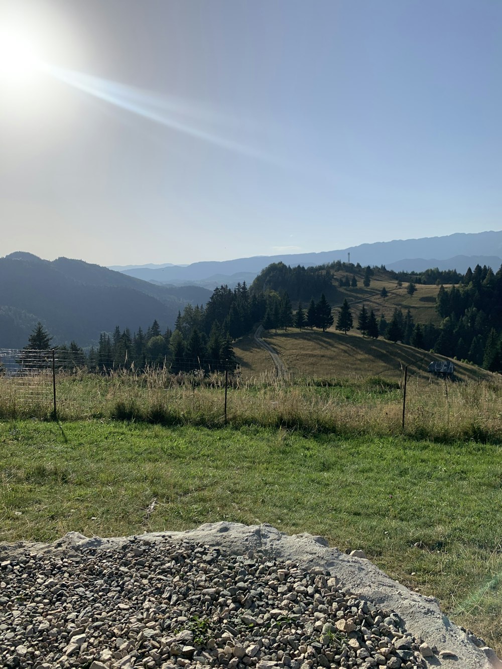 green grass field near mountain under white sky during daytime