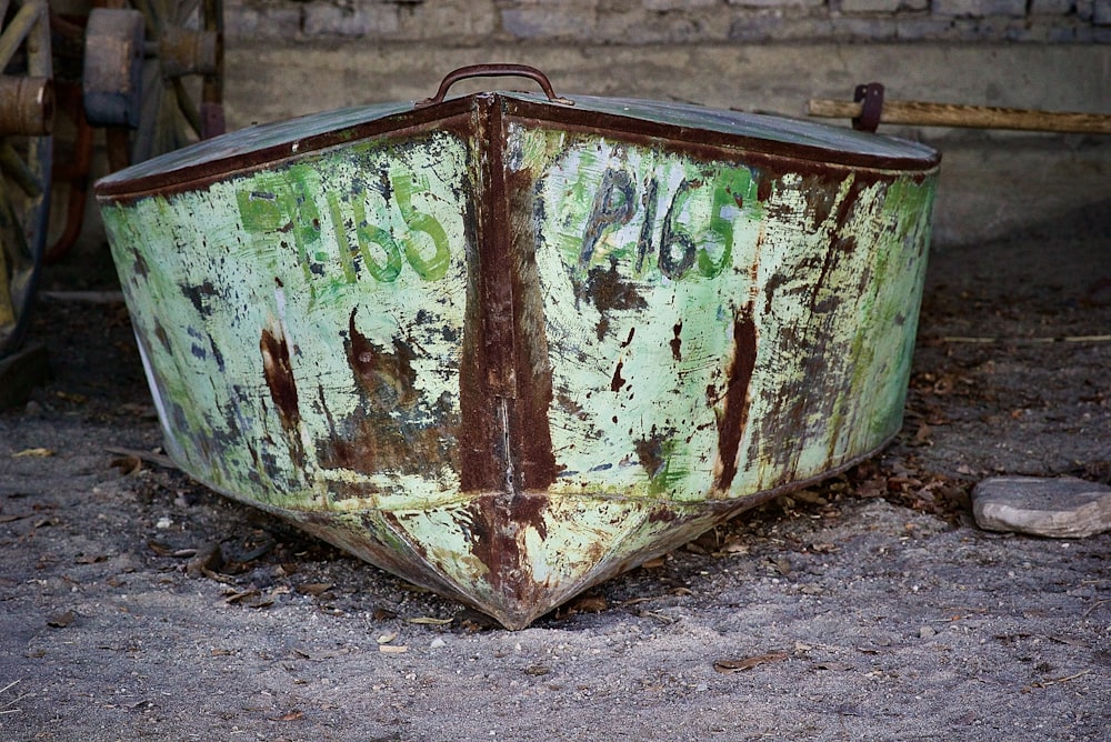 an old rusty boat sitting on the ground