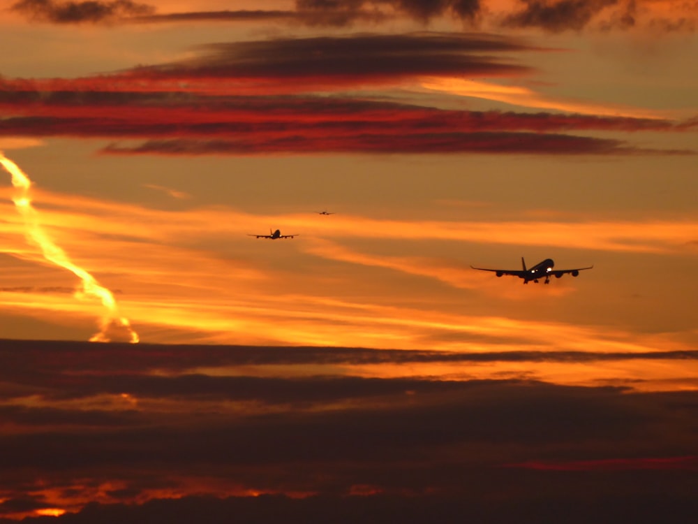 airplane flying over the clouds during sunset