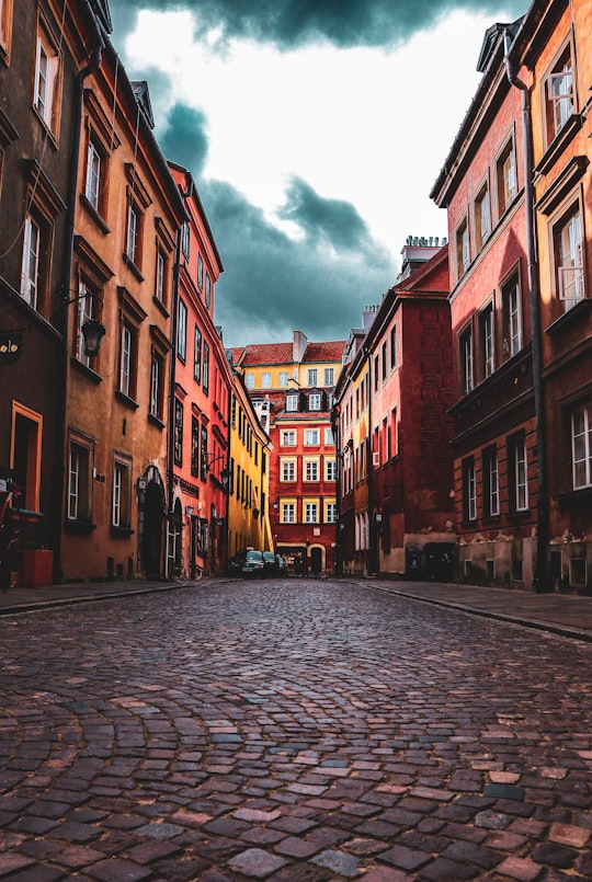 people walking on sidewalk between buildings during daytime in Old Town Market Square Poland