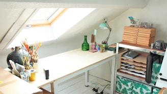 green glass bottle on white wooden desk