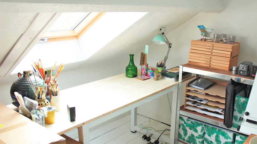 green glass bottle on white wooden desk