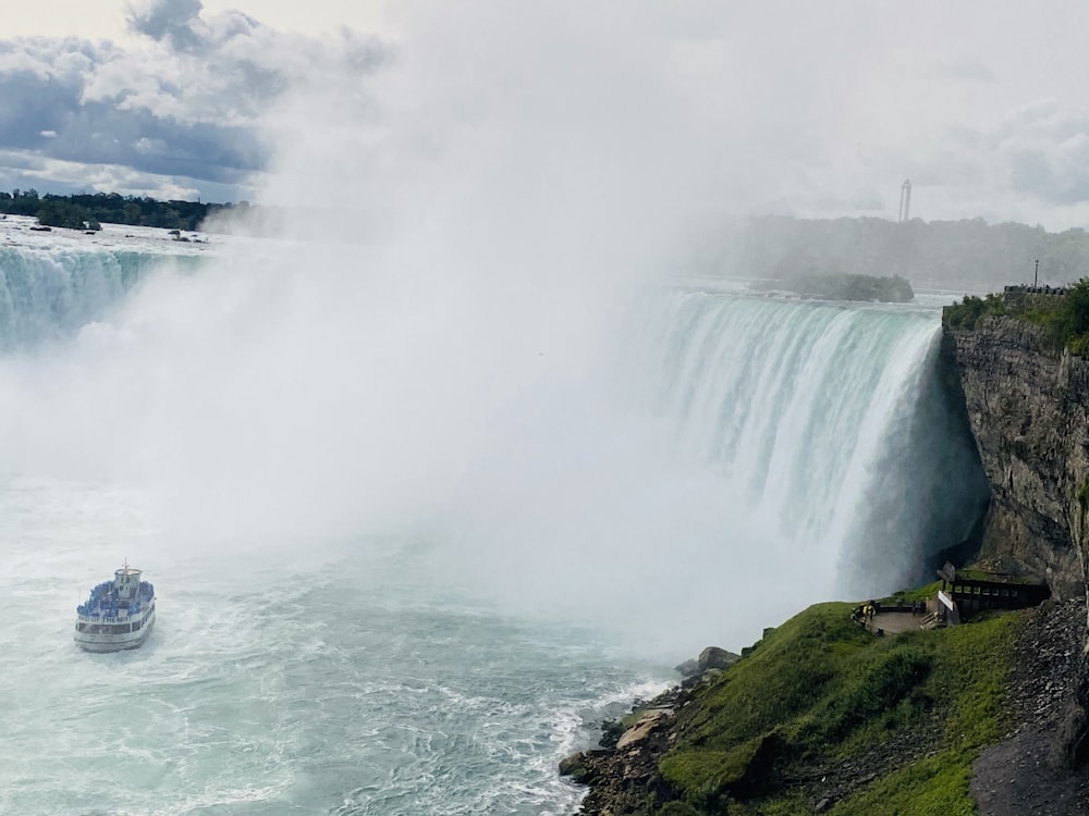 white boat on water falls