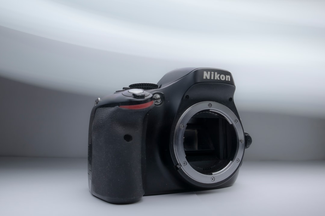 black nikon dslr camera on white surface