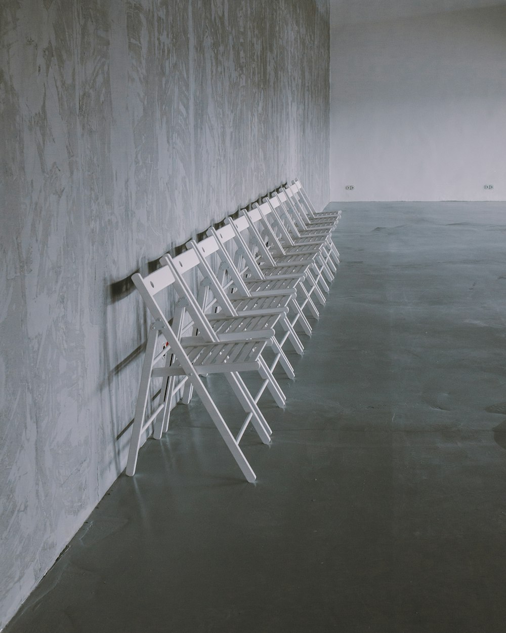 cadeiras dobráveis brancas no chão cinza
