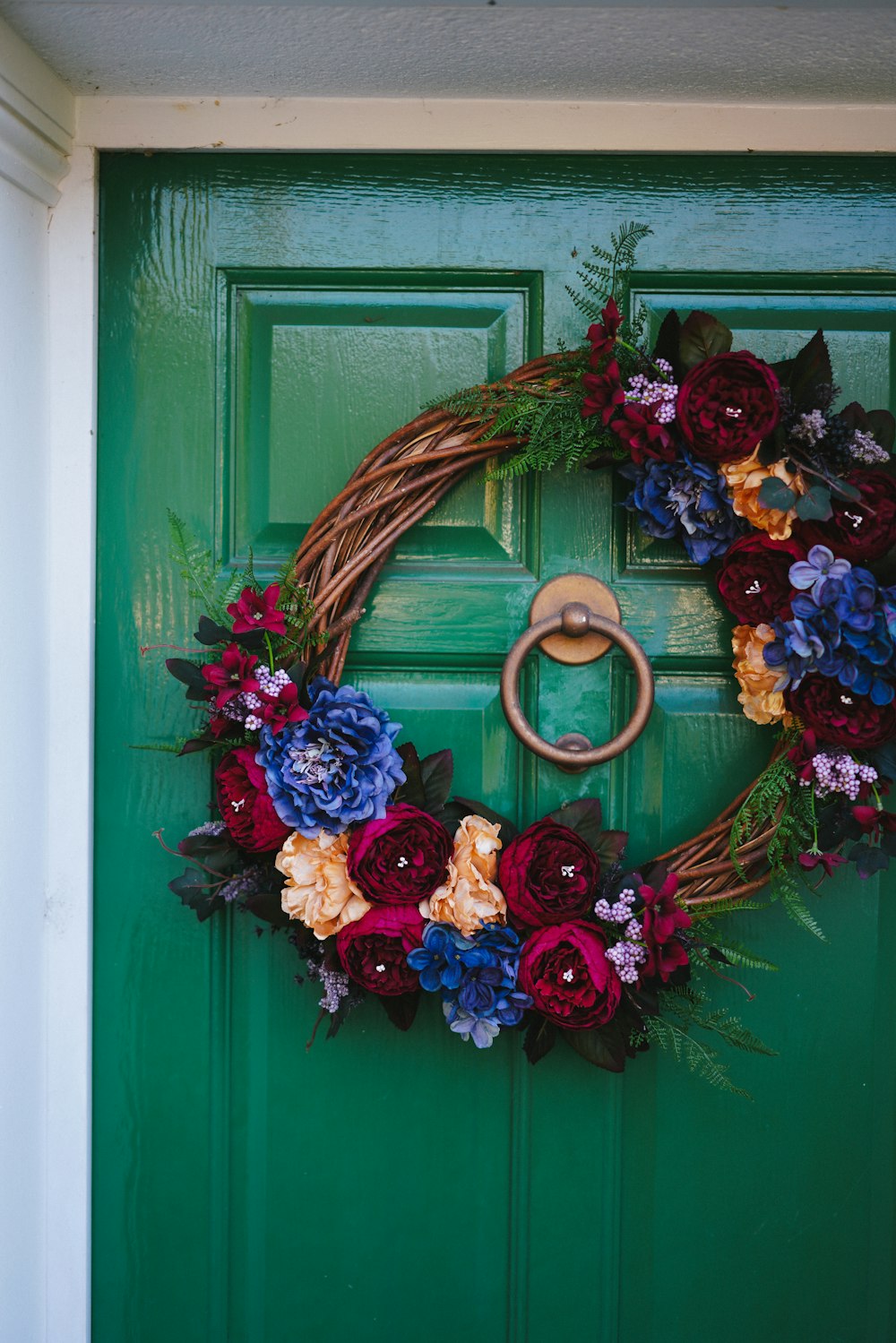 brown and red wreath on green wooden door