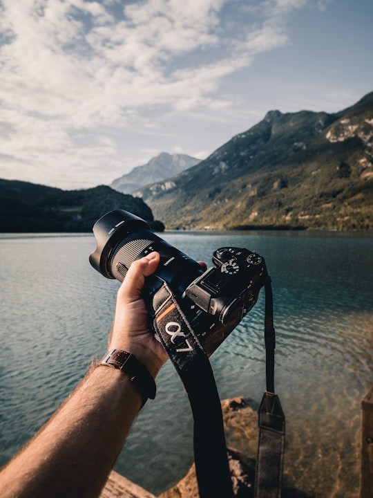 person holding black dslr camera in Comune di Cavazzo Carnico Italy