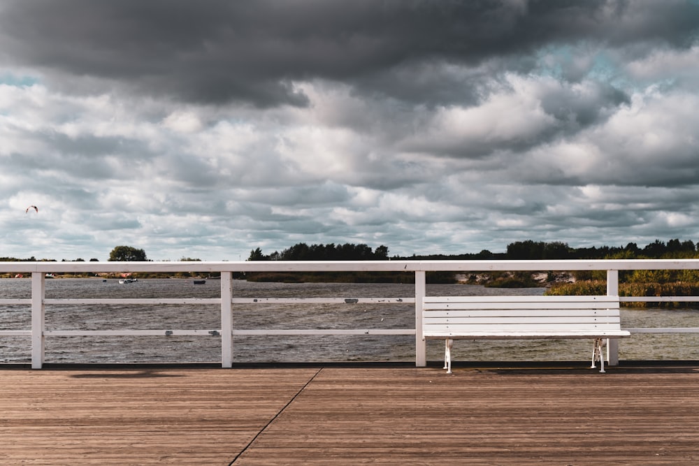 white metal fence on brown field under gray clouds