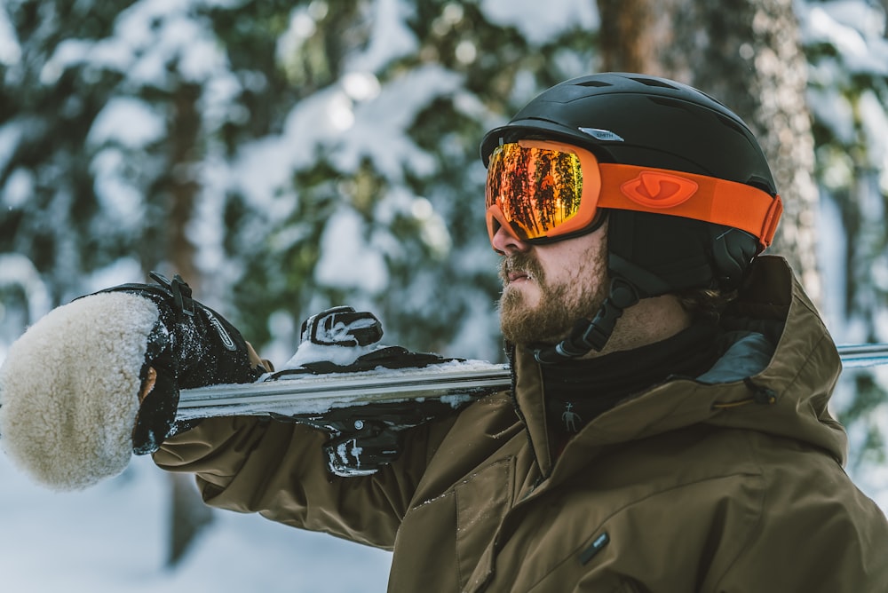 man in brown jacket wearing orange and black helmet