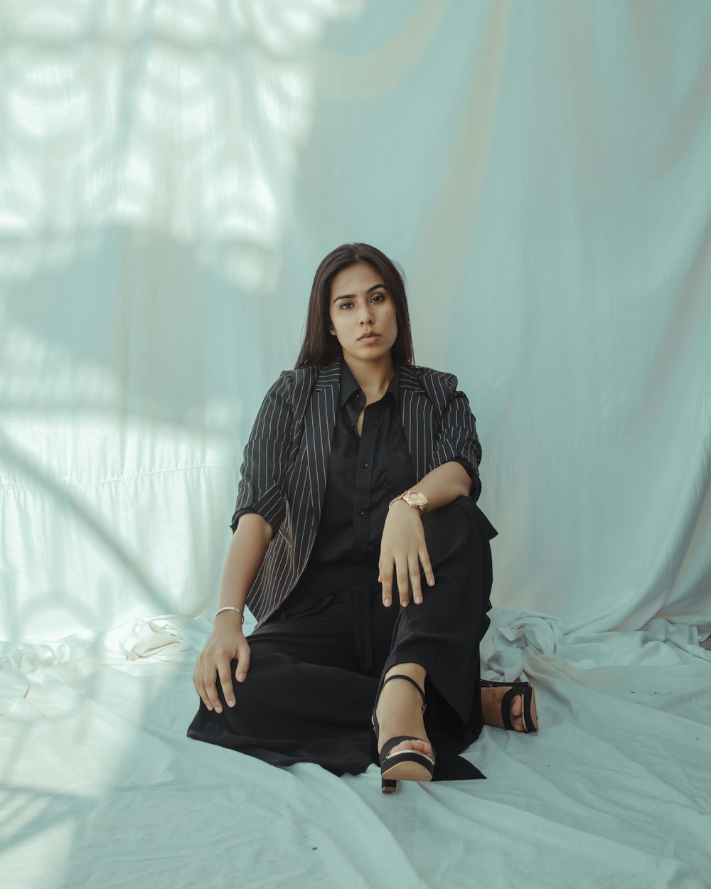 woman in black dress sitting on white textile