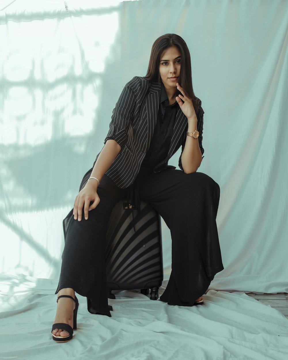 woman in black and white striped shirt and black pants sitting on bed