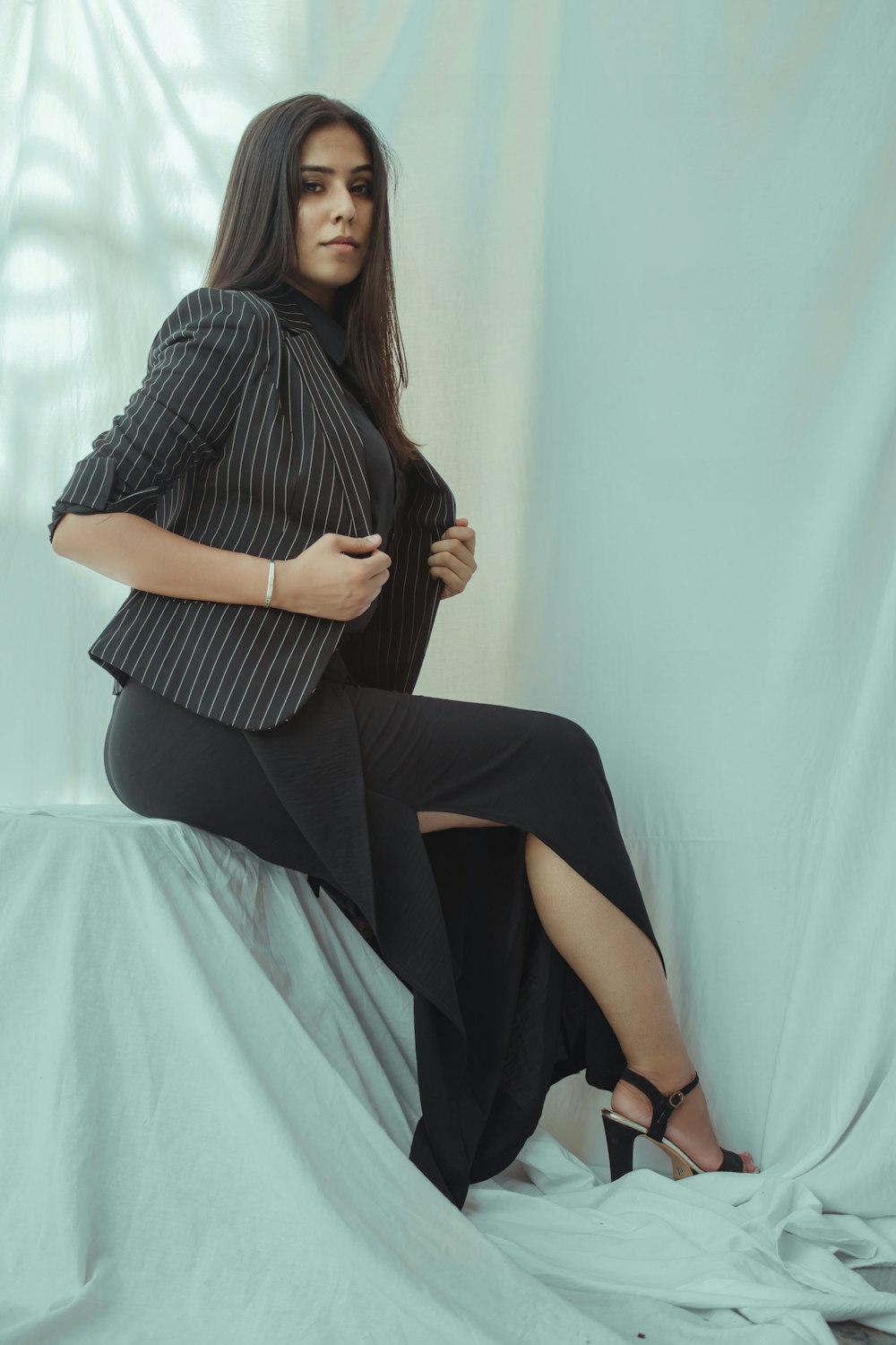 woman in black and white stripe dress sitting on bed