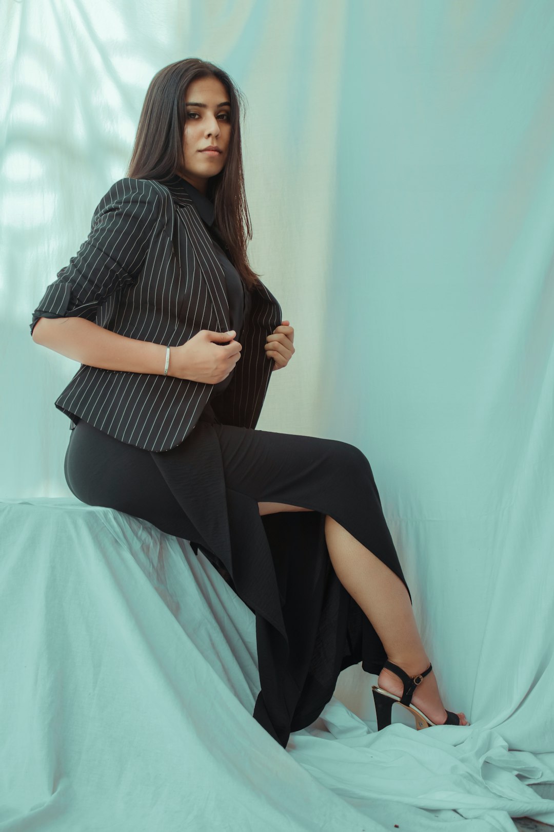 woman in black and white stripe dress sitting on bed