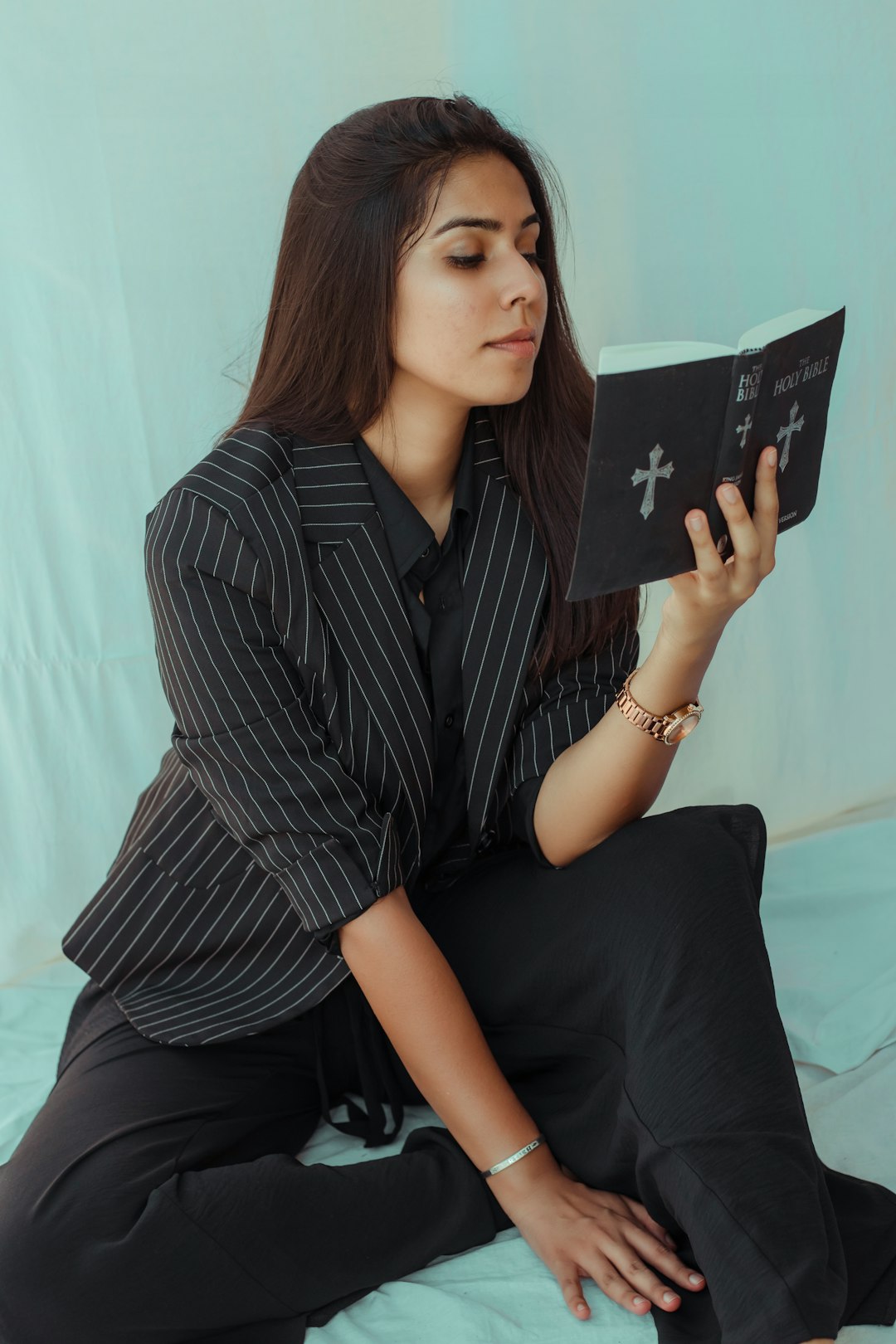 woman in black and white stripe dress shirt holding black book