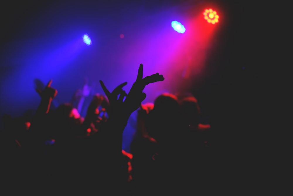 people raising their hands in front of stage